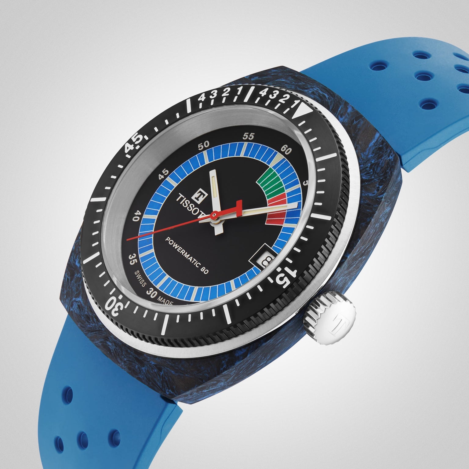 The Tissot Sideral S Powermatic 80 dive watch features a blue perforated strap, black rotating bezel, and multicolored dial, shown against a light gray background.