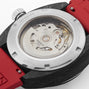 Close-up of the back of the Tissot Sideral S Powermatic 80, showing its exposed mechanical movement through a transparent caseback and featuring a red rubber strap.