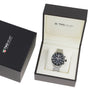 A TAG Heuer Formula 1 Chronograph with a black dial and silver metal band is shown in an open branded box beside a closed TAG Heuer box.