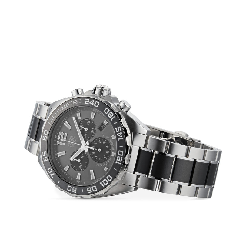 The TAG Heuer Formula 1 Chronograph features a stainless steel case, black dial with silver markers, and black accents on the bracelet, reflecting a motor-racing inspired design. Photographed on a white background.