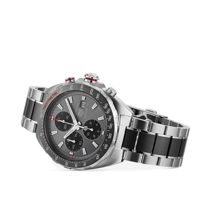 The TAG Heuer Formula 1 Chronograph features a stainless steel case, black bezel, three subdials, calibre 16 movement, date window, and a two-tone metal strap, shown on a white background.