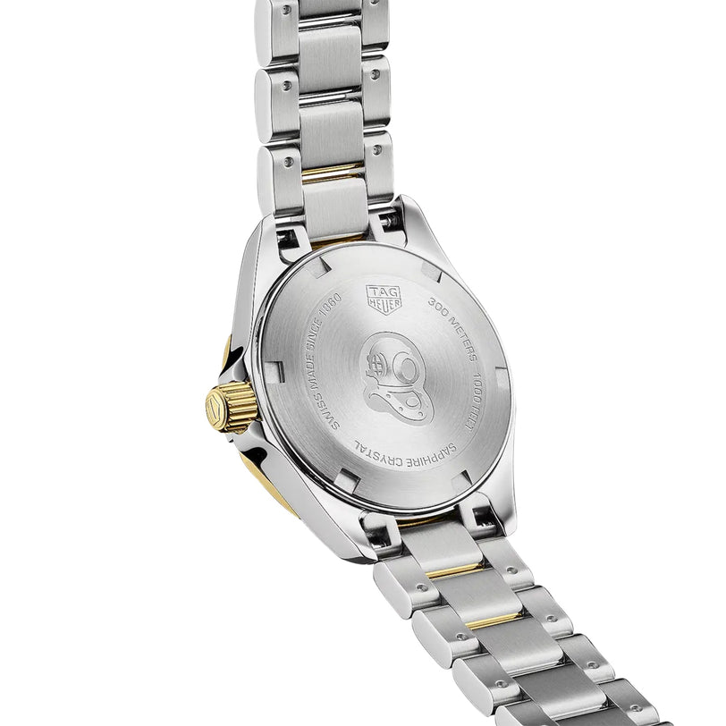 The back of a TAG Heuer Aquaracer Date watch features a stainless steel and two-tone bracelet, engraved with 200-meter water resistance and an image of a helmet.