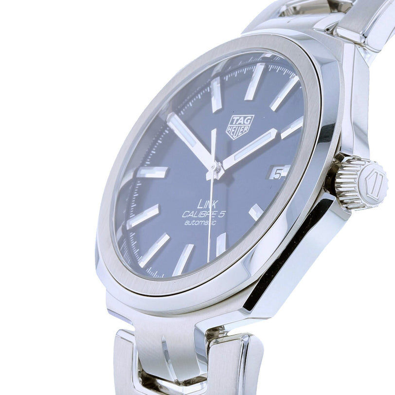 Close-up of a TAG Heuer Link Date men’s watch with sapphire crystal glass, blue dial, silver hour markers, and date display at 3 o’clock. The stylish stainless steel wristwatch showcases the iconic TAG Heuer design.