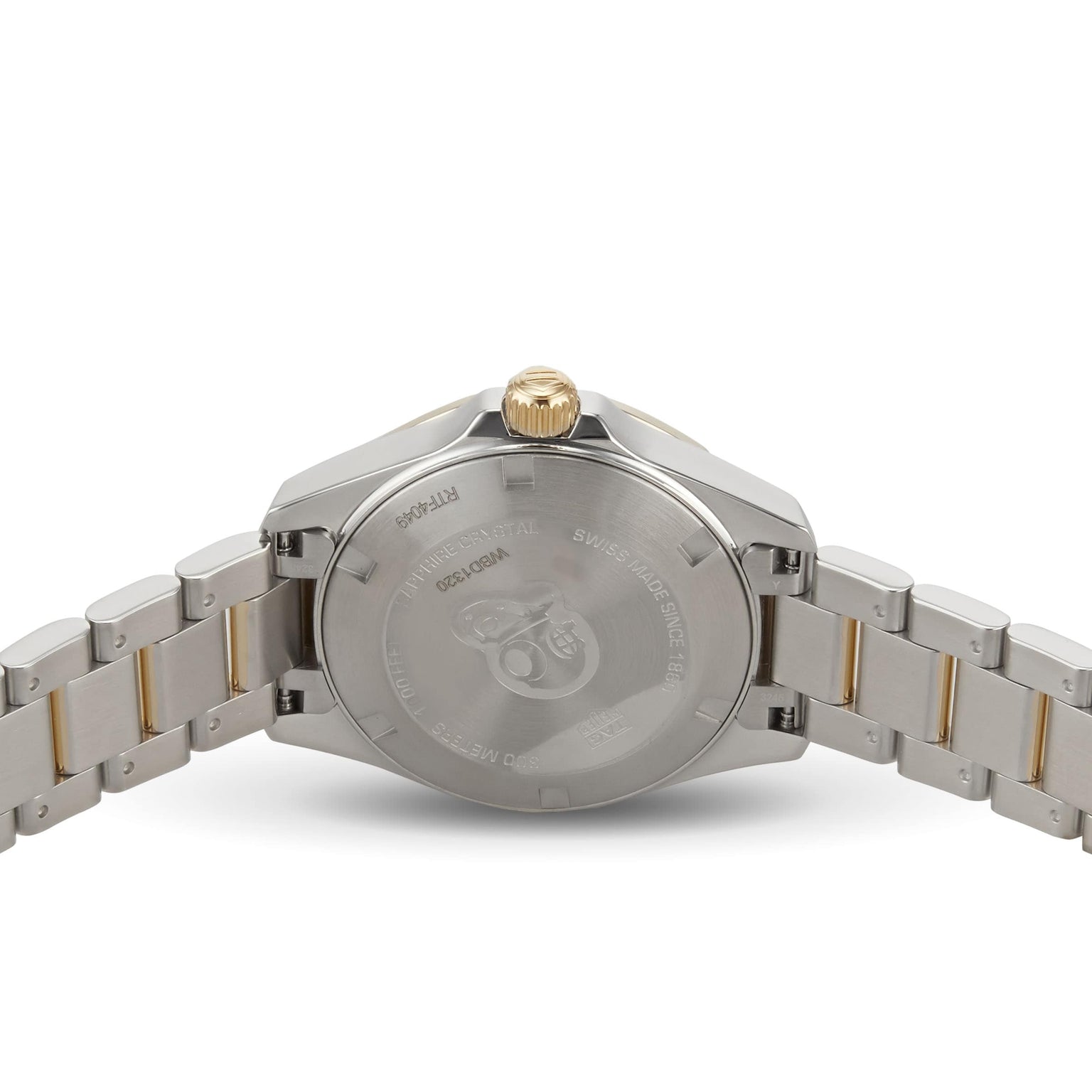 The image shows the back view of a TAG Heuer Aquaracer Date stainless steel sports watch, featuring a gold crown and gold accents on the bracelet.