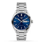 The TAG Heuer Carrera Day-Date is a silver wristwatch with a blue sunray dial, day-date display, calibre 5 automatic movement, and stainless steel bracelet, pictured on a white background.