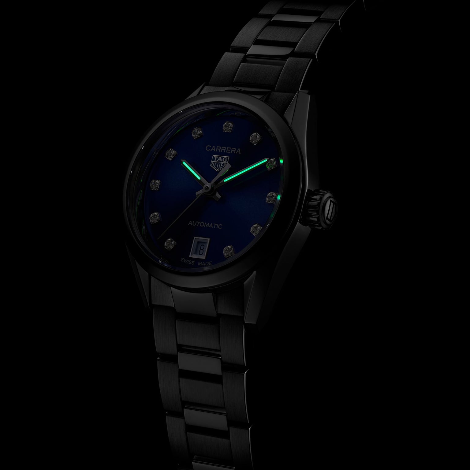 A TAG Heuer Carrera Date automatic watch with a blue sunray dial, diamond hour markers, and luminous hands is set against a dark background.