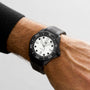 A persons wrist wearing a TAG Heuer Aquaracer Professional 300 Date dive watch with a white dial, black markers, date display, automatic movement, and black rubber strap.