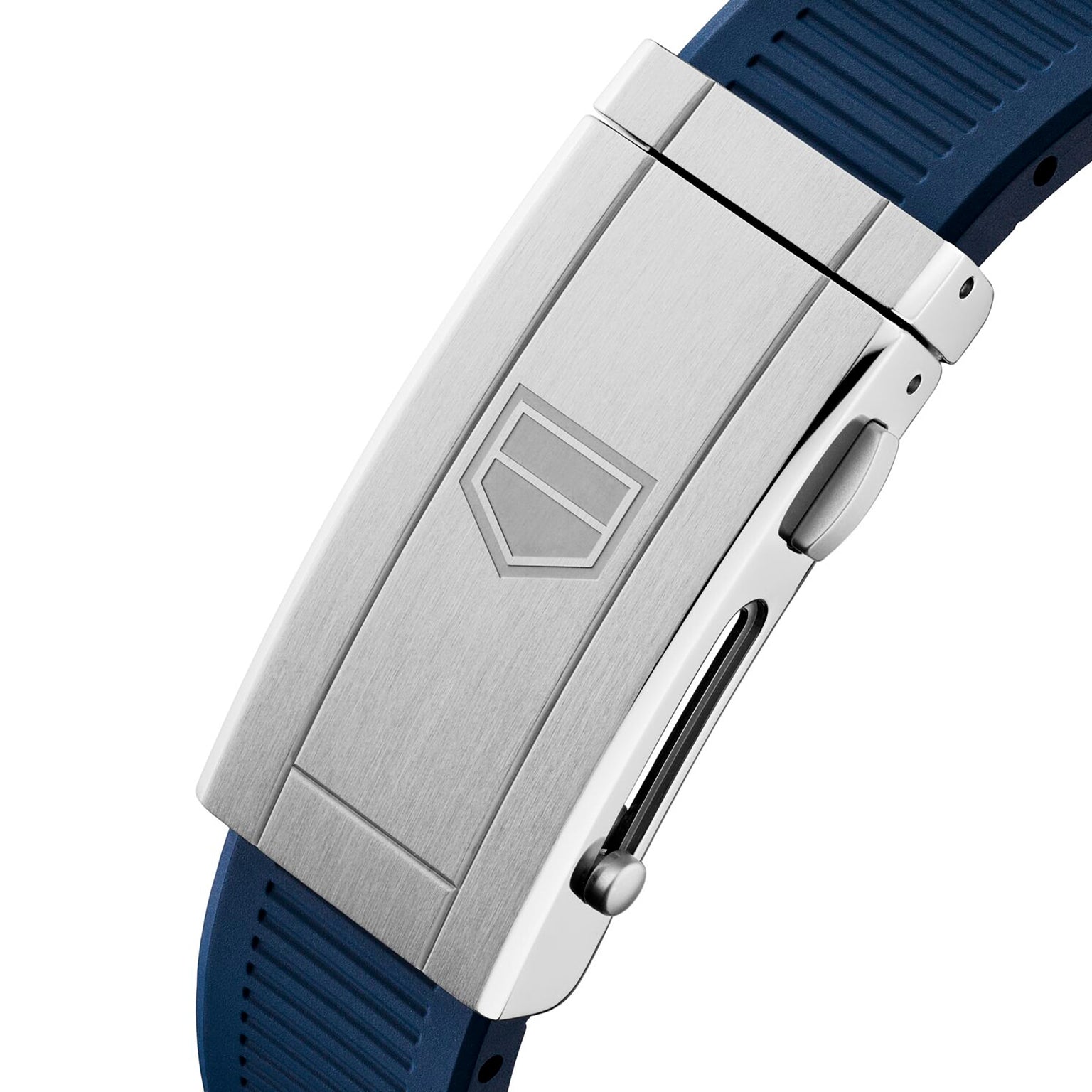 Close-up of a silver metal clasp with an engraved shield logo on the TAG Heuer Aquaracer Professional 300 GMT, attached to a blue textured rubber strap.