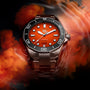 The TAG Heuer Aquaracer Professional 300 Orange Diver, featuring a vivid orange dial and black bezel in a 43mm stainless steel case, stands out against a swirling orange and black smoky backdrop, spotlighting its bold design.