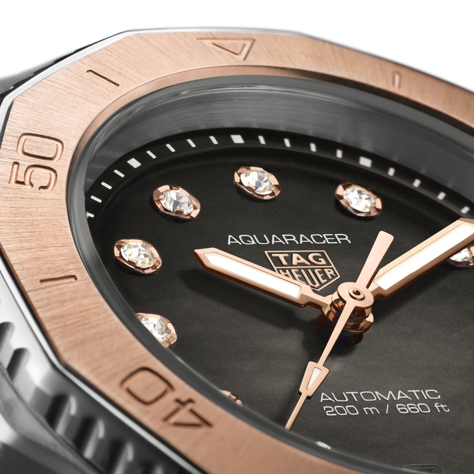 Close-up of the TAG Heuer Aquaracer Professional 200 Date watch featuring diamond indexes, a rose gold bezel, and text showing automatic movement plus water resistance to 200 meters (660 feet).