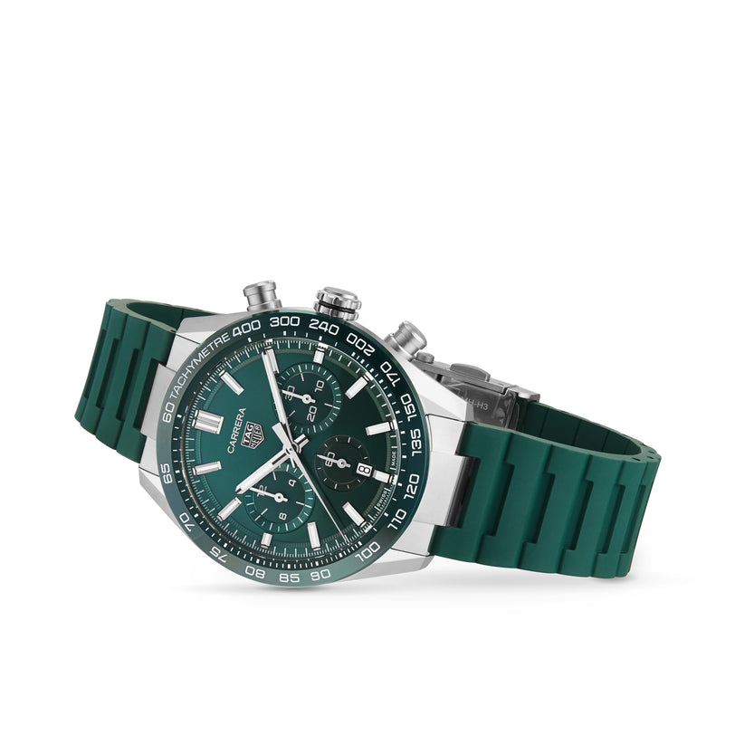 The TAG Heuer Carrera Chronograph, inspired by motor-racing heritage, features a green rubber strap, stainless steel case, three angled subdials on a white background, and is powered by the precise Heuer 02 calibre.