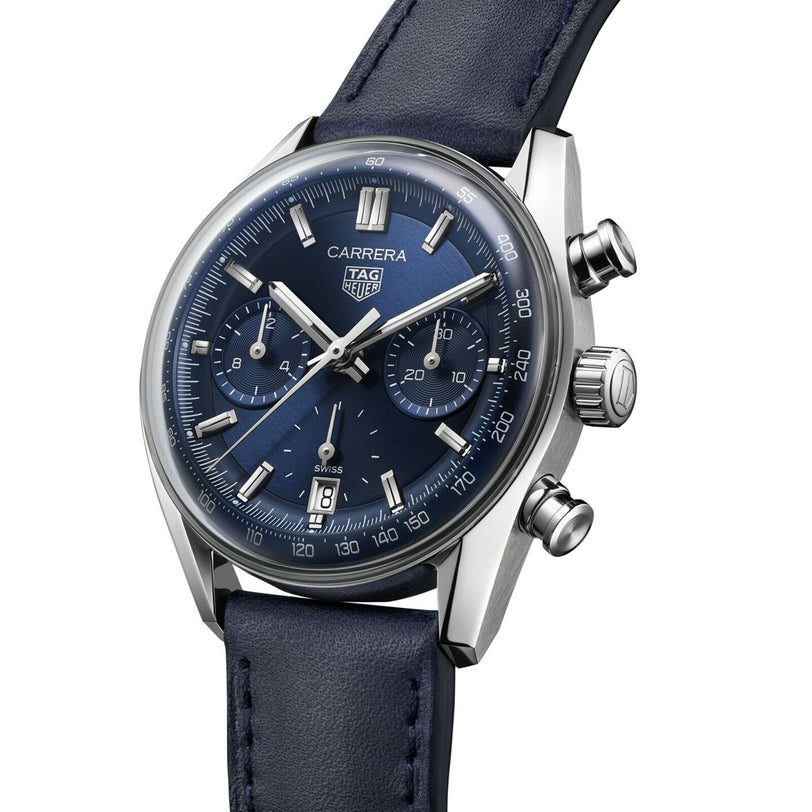 A close-up of a TAG Heuer Carrera Chronograph wristwatch featuring a blue dial, three subdials, date display, and blue leather strap—an homage to the adventurous spirit of the Carrera Panamericana race.