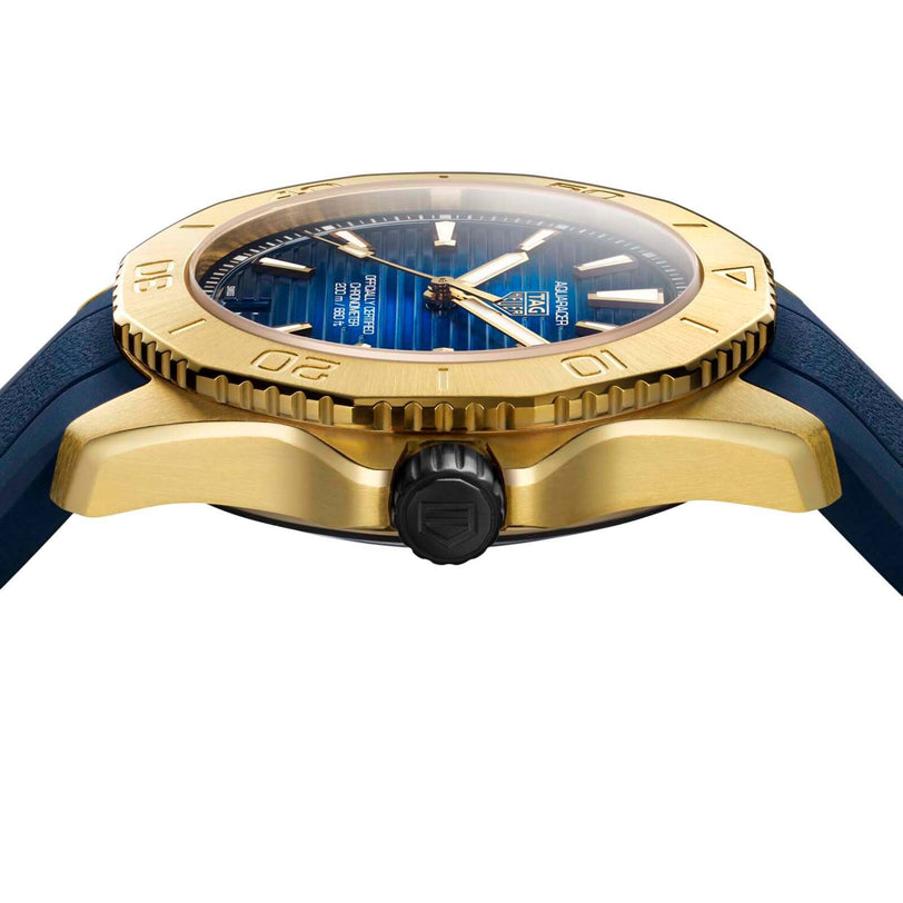 Side view of the TAG Heuer Aquaracer Professional 200 Date in yellow gold, featuring a blue dial with horizontal lines, a blue rubber strap, and powered by the precise TH31-00 calibre movement.