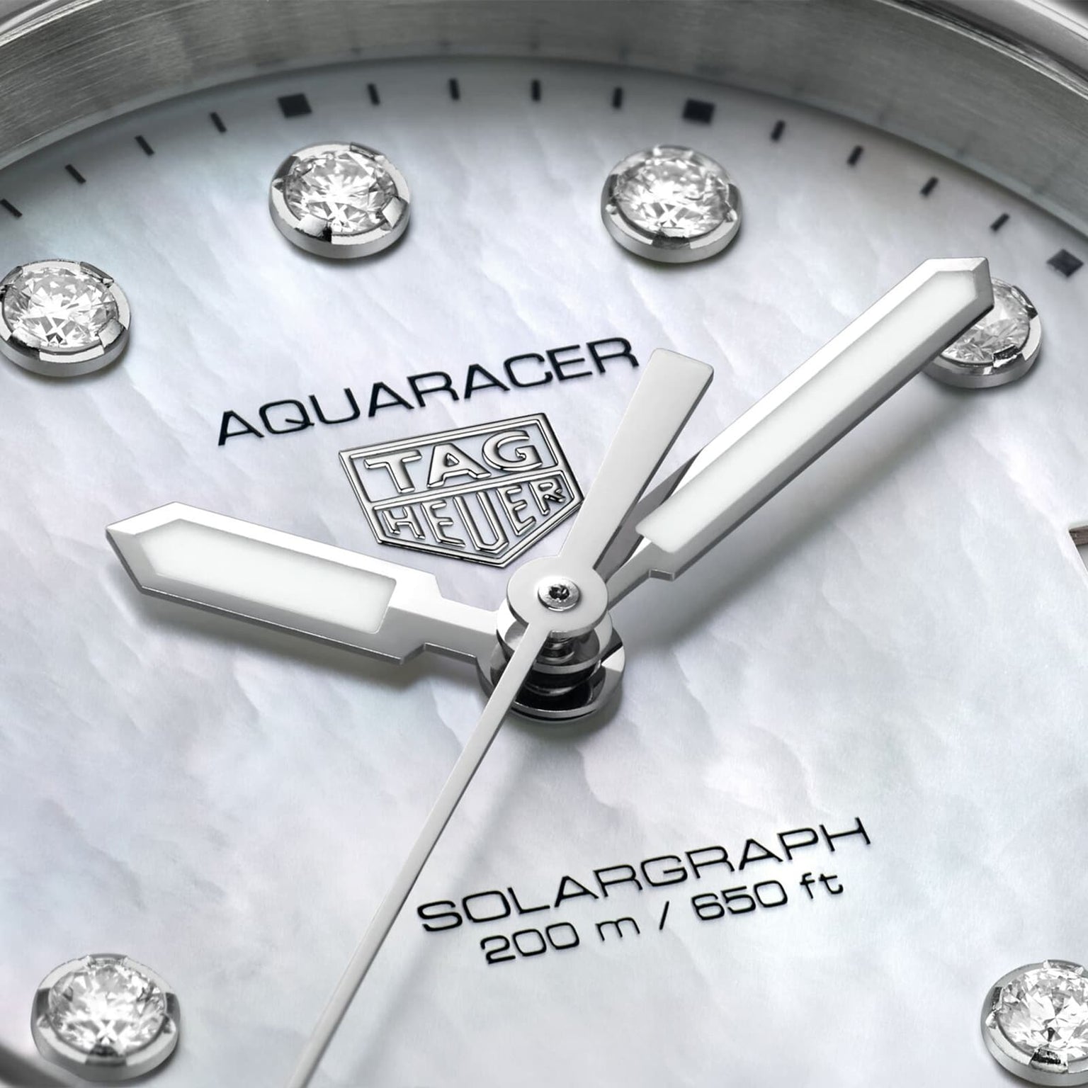Close-up of a TAG Heuer Aquaracer 200 Professional Solargraph watch face, showcasing diamond hour markers, silver hands, and 200m/650ft water resistance.