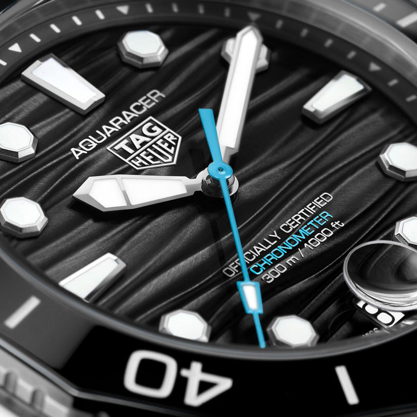 Close-up of a TAG Heuer Aquaracer Professional 300 Date watch face featuring a textured dial, bold hour markers, and precise time display.