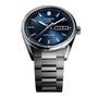 TAG Heuer Carrera Day-Date watch in silver with a blue dial, day and date display, on a metal bracelet.