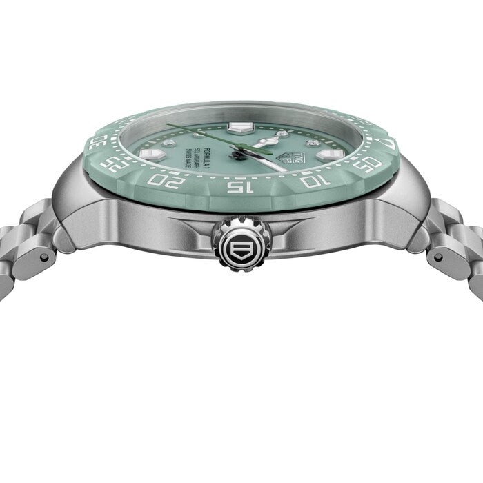 Silver watch with a green face on a white background