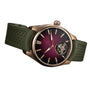 The H. Moser & Cie Pioneer Tourbillon Burgundy features a burgundy dial, gold case, green strap, and a visible tourbillon at 6 o’clock.