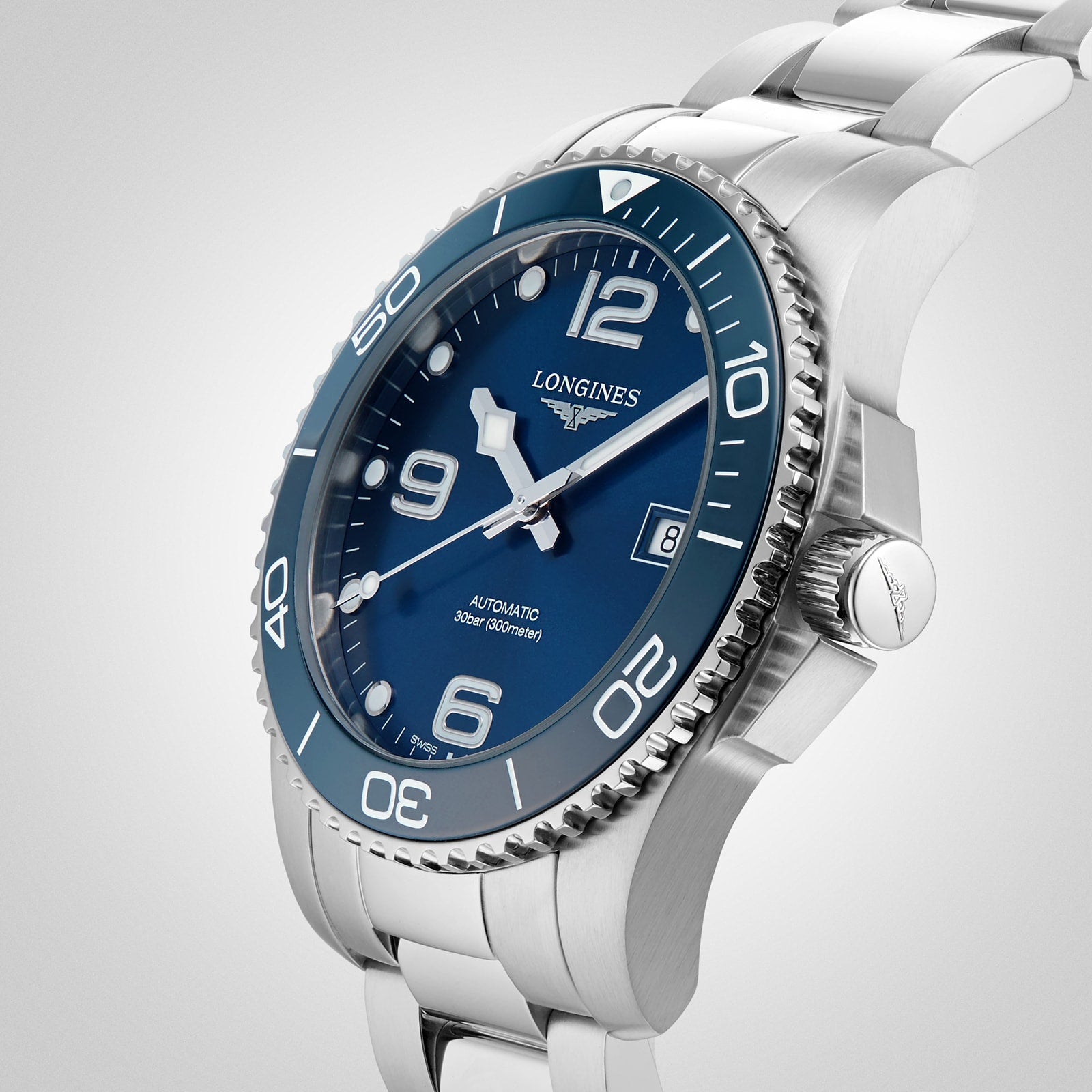 The Longines HydroConquest, a stainless steel diving watch with a blue dial, silver hour markers, and rotating bezel, is displayed against a plain light background. This stylish timepiece is elegant and water resistant.
