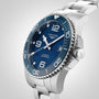 The Longines HydroConquest, a stainless steel diving watch with a blue dial, silver hour markers, and rotating bezel, is displayed against a plain light background. This stylish timepiece is elegant and water resistant.