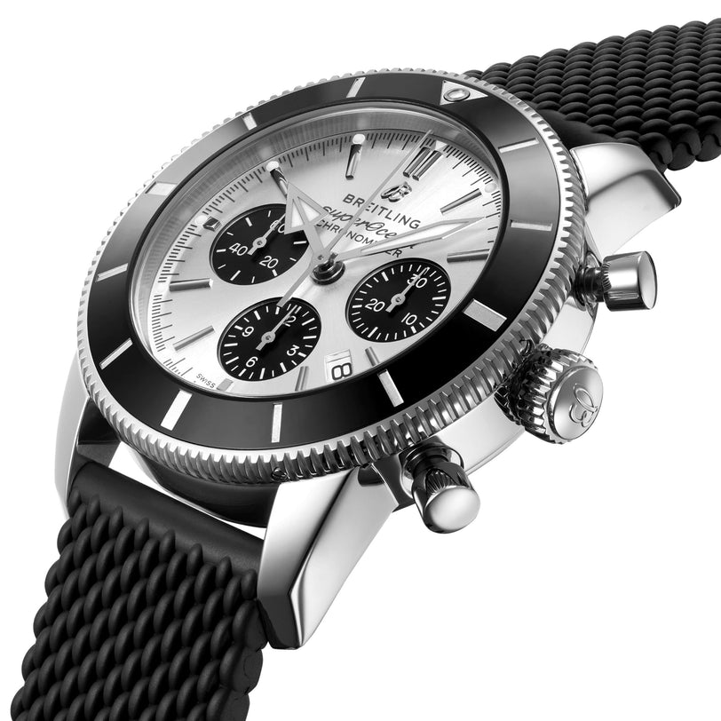 The Breitling Superocean Heritage B01 Chronograph 44 is a silver wristwatch with a black bezel, three subdials, and a textured black rubber strap. The dial displays the Breitling logo and the watch is water resistant for everyday wear.