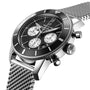 The Breitling Superocean Heritage B01 Chronograph 44 features a stainless steel case, black bezel and dial, three subdials, a metal mesh strap, and is powered by the Breitling 01 calibre, displayed at an angle.