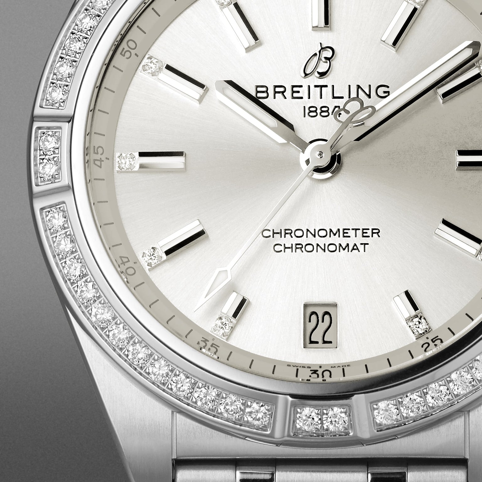 Close-up of the Breitling Chronomat Automatic 36 watch with a silver dial, diamond hour markers, date display at 6 o’clock, diamond bezel, and signature Rouleaux bracelet.