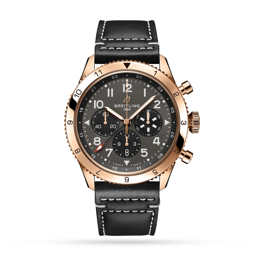 The Breitling Super AVI B04 Chronograph GMT 46 P-51 Mustang features a black dial, gold case, three subdials, date window, and a black leather strap with white stitching, shown on a white background.