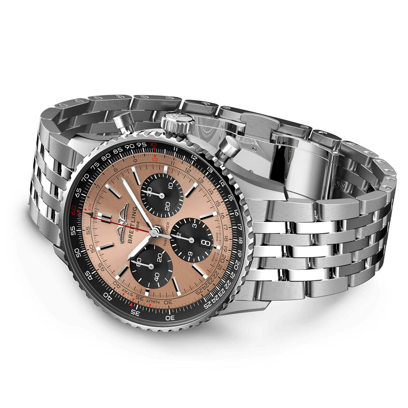 The Breitling Navitimer B01 Chronograph 43 is a stainless steel watch with a rose gold dial, black subdials, and a metal link bracelet, powered by the Breitling 01 calibre, displayed angled on a white background.