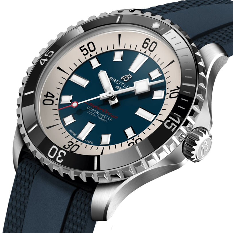 Close-up of a Breitling Superocean Automatic 44 watch with a blue dial, white and silver markers, rotating bezel, textured blue strap, and water-resistant automatic movement.