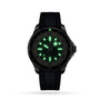 The Breitling Superocean Automatic 44 wristwatch, featuring a black band, is shown in the dark with glowing green luminescent hour markers and hands, emphasizing its automatic movement and water-resistant design.