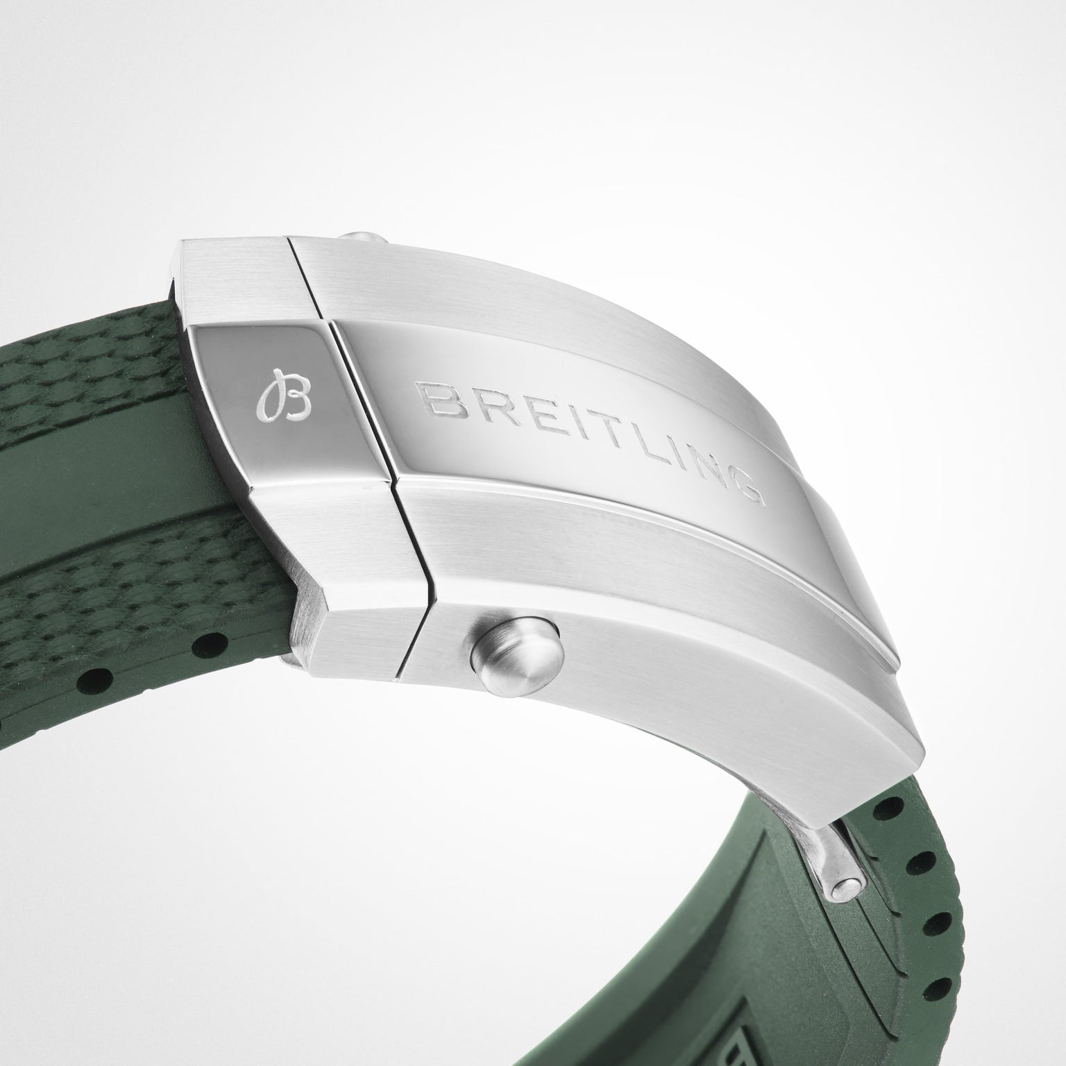 Close-up of the Breitling Superocean Automatic 44 stainless steel clasp with engraved logo on a green rubber strap, showcasing its diving watch design and water resistance against a white background.
