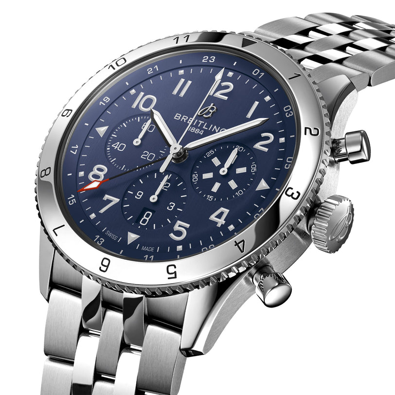A close-up of the Breitling Super AVI B04 Chronograph GMT 46 Tribute To Vought F4U, a stainless steel pilots watch with a blue dial, chronograph subdials, metal link bracelet, and the renowned Breitling B04 Manufacture calibre.