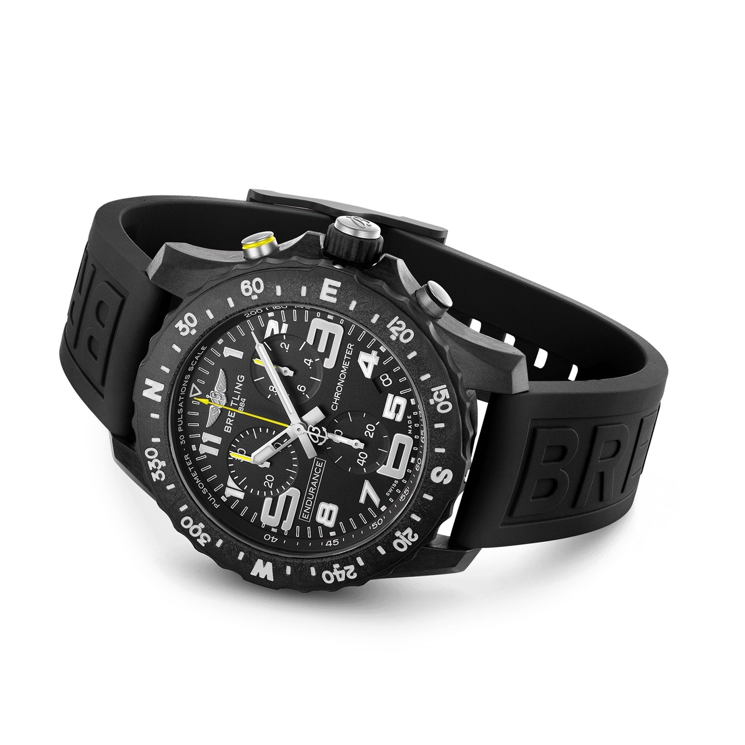 A black Breitling Endurance Pro 44 chronograph wristwatch with large numerals, subdials, a rotating bezel made from lightweight Breitlight®, and a rubber strap is displayed on a flat surface.