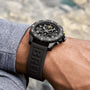 A person wearing a Breitling Endurance Pro 44 wristwatch with a black textured rubber strap and a compass bezel.