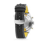 A close-up of the back of a Breitling Classic AVI Chronograph 42 Tribute To Vought F4U watch with a black leather strap, yellow inner lining, and silver buckle engraved with the brand name.