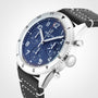 The Breitling Classic AVI Chronograph 42 Tribute To Vought F4U features a blue dial, white numerals, chronograph subdials, and a black leather strap with white stitching, shown at an angle to highlight its pilot watch heritage.