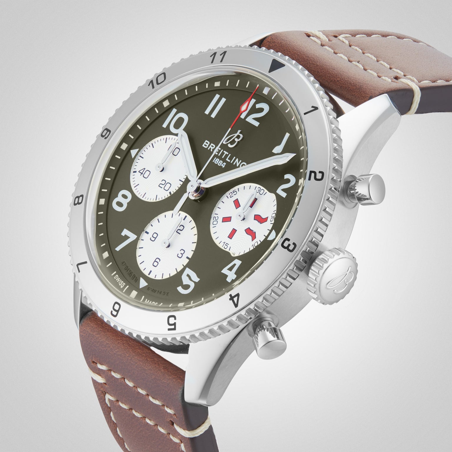 The Breitling Classic AVI Chronograph 42 Curtiss Warhawk features a green dial with three white subdials, silver case, brown leather strap, and silver crown and bezel—powered by the reliable Breitling 23 calibre.
