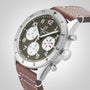The Breitling Classic AVI Chronograph 42 Curtiss Warhawk features a green dial with three white subdials, silver case, brown leather strap, and silver crown and bezel—powered by the reliable Breitling 23 calibre.