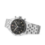 The Breitling Classic AVI Chronograph 42 P-51 Mustang is a stainless steel pilots watch with a black dial, silver markers, three subdials, and a metal bracelet, displayed on white and inspired by the legendary P-51 Mustang.
