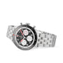 The Breitling Classic AVI Chronograph 42 Mosquito is a stainless steel watch with a black dial, white subdials, red accents, and a metal link bracelet—shown at an angle, it pays tribute to aviation history.