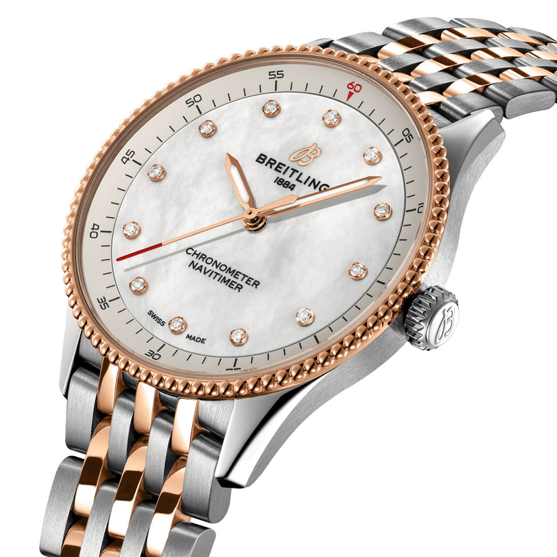 The Breitling Navitimer 32 features a white dial, gold hour markers, diamond indices, SuperQuartz™ movement, and a two-tone metal bracelet.