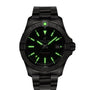 The Breitling Avenger Automatic 42 is a black wristwatch with luminous green hour markers and hands, a military-inspired black dial, date display at 3 o’clock, and a metal bracelet.