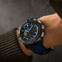 A person wearing a Breitling Avenger B01 Chronograph 44 Night Mission US Naval Academy with a blue dial, black bezel, and blue strap featuring the renowned Manufacture Caliber 01, seen from above.