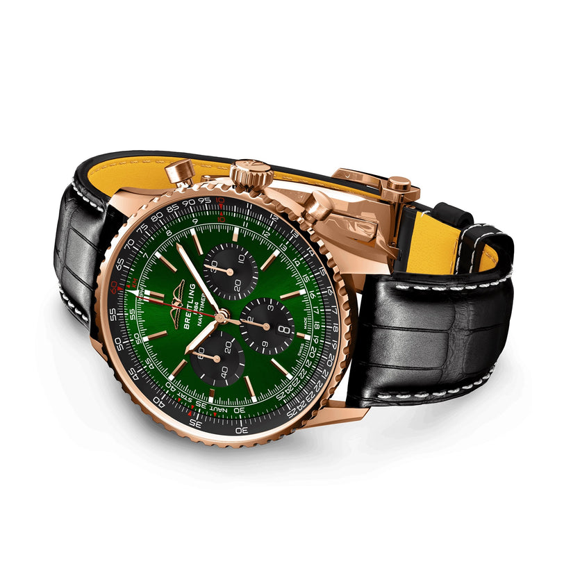 A Breitling Navitimer B01 Chronograph 46 in gold, featuring a green dial, multiple subdials, and a black leather strap with white stitching, photographed on a white background.