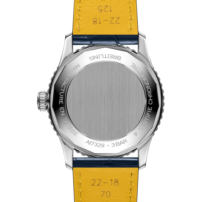 Back view of the Breitling Navitimer Automatic 41 showing its metal case back with engraved branding, certification details, model number, and a yellow leather strap, powered by the Breitling 17 calibre.