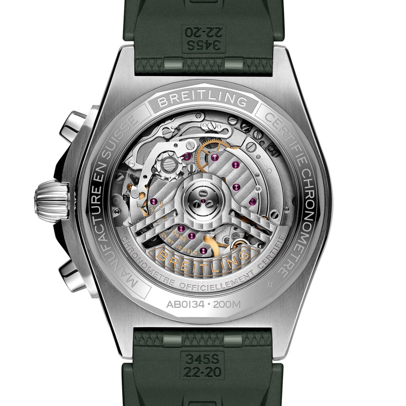 Close-up of the Breitling Chronomat B01 42’s back reveals its mechanical movement through a transparent case back, detailed engravings, and a green rubber strap.