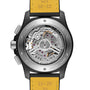 Close-up of the Breitling Avenger B01 Chronograph 42’s back, revealing its mechanical movement marked “Swiss Made” and “Chronomètre Officiellement Certifié,” with a yellow leather strap—honoring the Frecce Tricolori’s resilience.