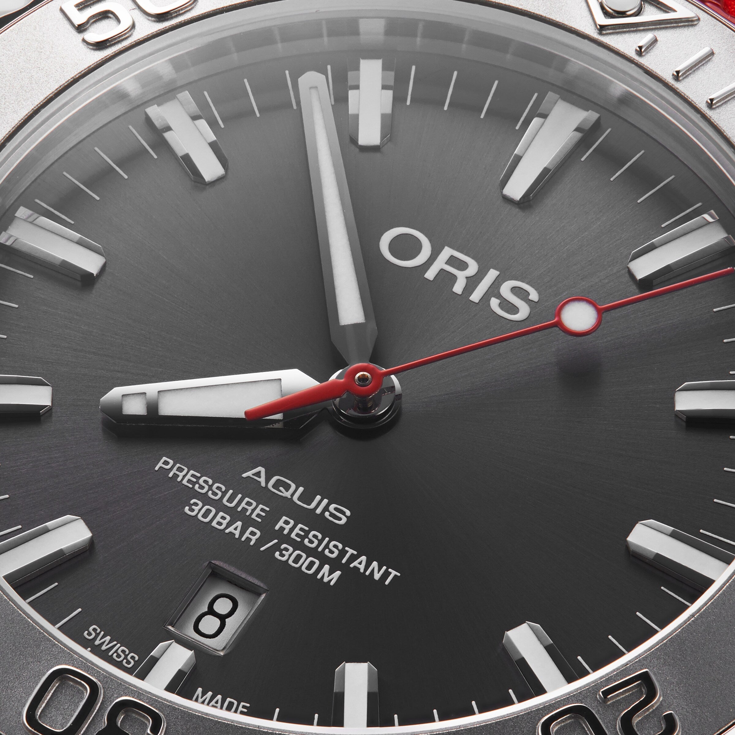 Close-up of the Oris Aquis Date Relief watch face, showing the brand name, date at 6 o’clock, and 30 bar/300 m water resistance—a true diver’s timepiece.