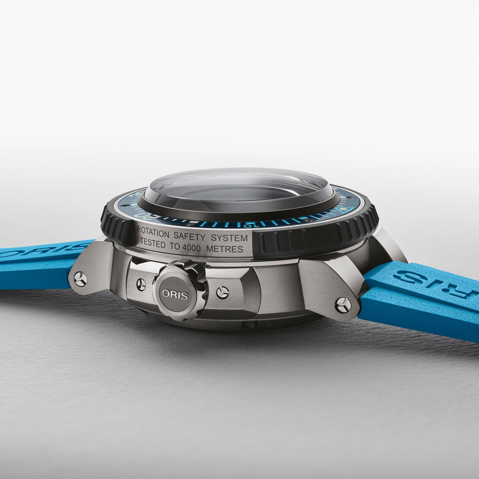 Side view of the Oris Aquis Pro 4000M, a dive watch with a blue strap, metal case, crown, Calibre 400 movement, and water resistance tested to 4000 metres.